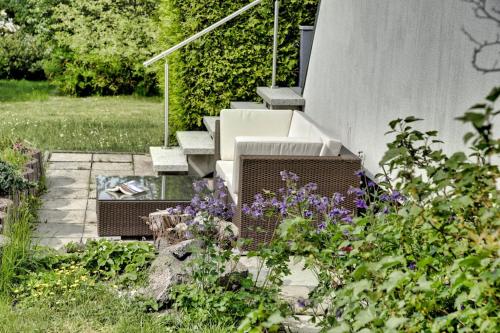 un jardín con flores púrpuras y un conjunto de escaleras en Chalet Alba, en Lichtenberg