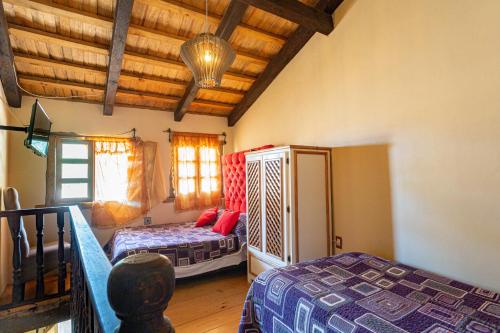 a bedroom with two beds and a wooden ceiling at Hotel Boutique El Rincón in Zacatlán