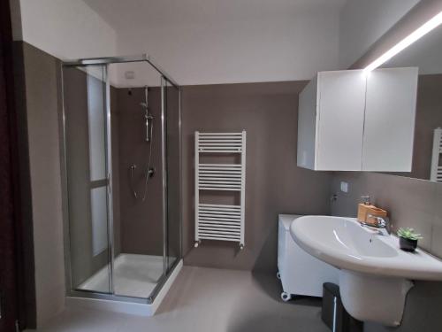 La salle de bains est pourvue d'une douche et d'un lavabo. dans l'établissement Fabula Home Rental - Casa Cuneo, à Costa Volpino