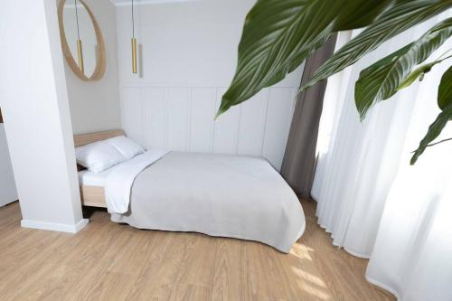 Un dormitorio con una cama y una planta. en Design & Relax #Altstadt #Sauna en Lutherstadt Wittenberg