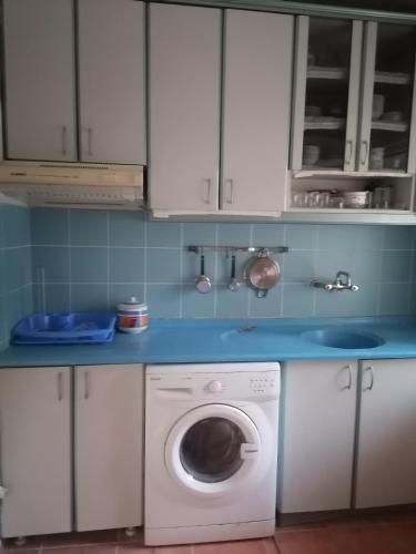 y cocina con lavadora y armarios blancos. en Pasa doga villa en Kumluca
