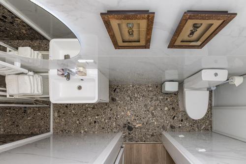 een witte badkamer met een wastafel en een aanrecht bij BASOM home - Mano jūra 3 Kunigiškiai - by Hello Sea homes in Palanga