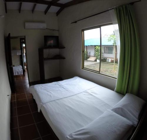 a bedroom with a large bed and a window at Cabañas El Samán Villavicencio in Villavicencio
