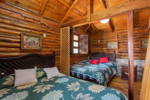 a bedroom with two beds in a log cabin at Hotel Boutique El Rincón in Zacatlán