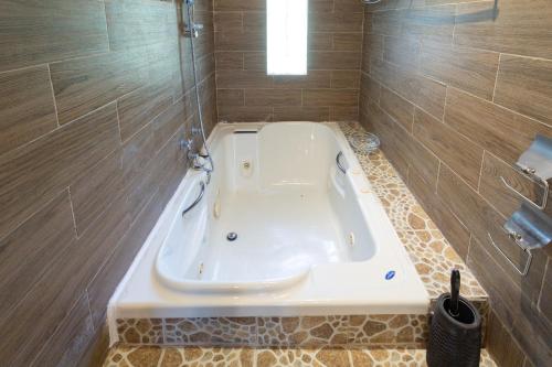 a bath tub in a bathroom with brown tiles at Hotel Boutique El Rincón in Zacatlán