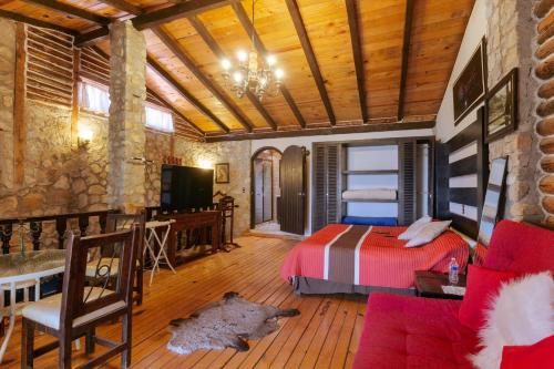a bedroom with a bed and a couch and a tv at Hotel Boutique El Rincón in Zacatlán