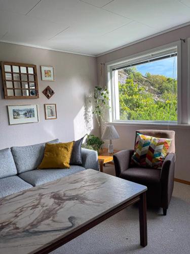 a living room with a couch and a window at Havgaarden, apt 1 in Stapnes