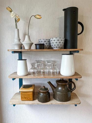 a shelf with pots and jars and a lamp on it at Havgaarden, apt 1 in Stapnes