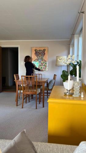 a woman sitting at a table in a living room at Havgaarden, apt 1 in Stapnes