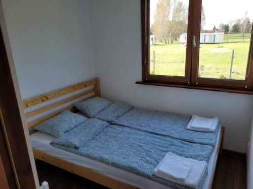 a bed in a room with two pillows and a window at Domek letniskowy w Karwiku in Karwik