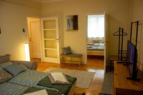 a living room with a couch and a tv in it at Foxy Apartman in Eger