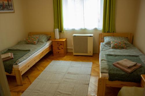 a bedroom with two twin beds and a window at Foxy Apartman in Eger