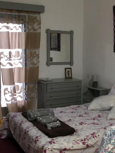 a bedroom with a bed with a dresser and a mirror at Tasos_Studios&Apartments 2 in Kranidi