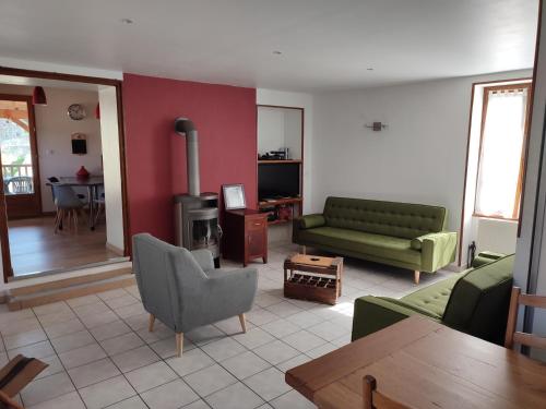 een woonkamer met een groene bank en een open haard bij Le Clos du Château in Rully