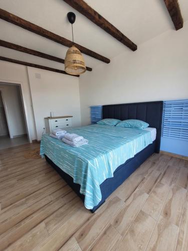 a bedroom with a bed with a blue comforter at Villa Bosna Near Dubrovnik very beautiful Villa entirely privatized swimming pool, jacuzzi, sauna, billiard, ping-pong in Ivanica