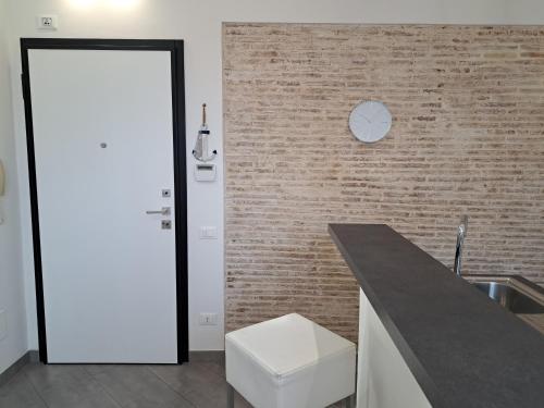 una cucina con porta bianca e muro di mattoni di CASA MATTIA a Livorno