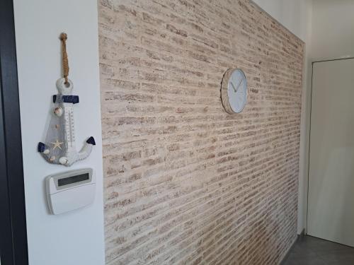 un mur en briques dans une pièce avec une horloge dans l'établissement CASA MATTIA, à Livourne