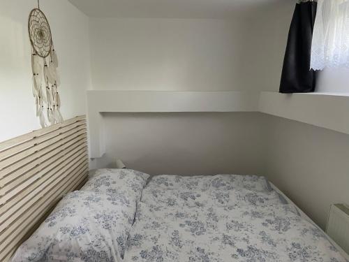 een kleine slaapkamer met een bed met een bloemdekbed bij Apartmán Ivona in Štípa