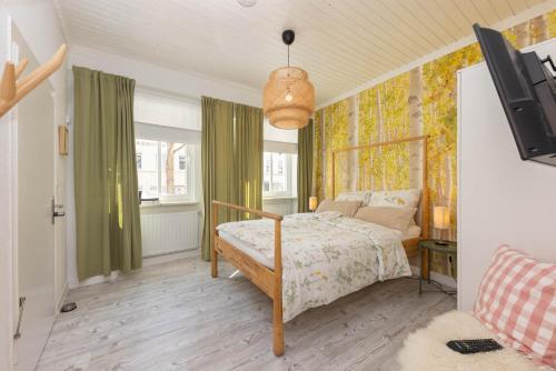 1 dormitorio con 1 cama y TV. en FerienNest Bad Ems, Appartment WaldNest en Bad Ems