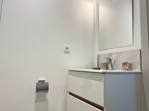 a white kitchen with a sink and a white cabinet at Hotel TULTY in Tours