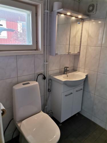 a bathroom with a white toilet and a sink at DecaVillage Studios in Kuivanto