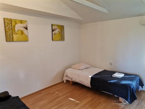 Un dormitorio con una cama y dos cuadros en la pared. en DecaVillage Studios, en Kuivanto
