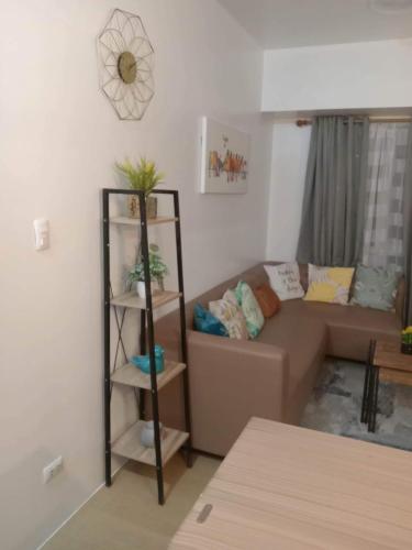 a living room with a couch and a shelf at 1 BR Centrio Tower 926 in Cagayan de Oro