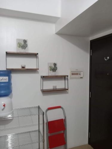 a room with two shelves on a wall with a red chair at 1 BR Centrio Tower 926 in Cagayan de Oro