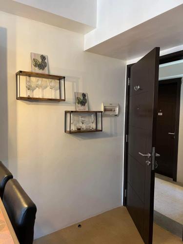 a hallway with a black door and shelves on a wall at 1 BR Centrio Tower 926 in Cagayan de Oro