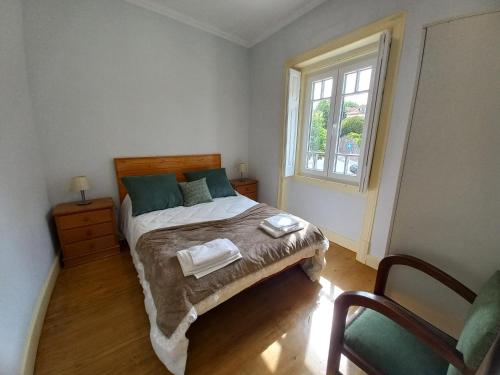 辛特拉的住宿－CASA MARIANA 1 - Viver a Vila，一间卧室设有一张床、一个窗口和一把椅子