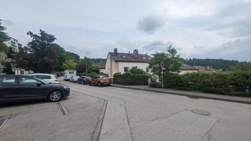 una calle con coches estacionados al costado de la carretera en Reiheneckhaus mit Garten und Terasse, en Tettnang