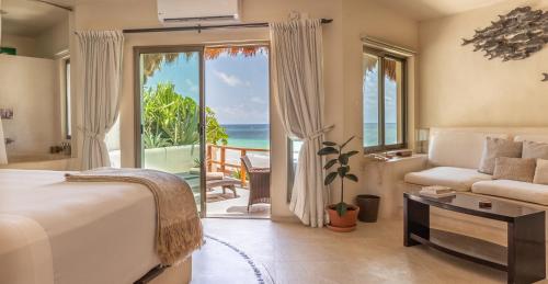 a bedroom with a bed and a view of the ocean at Mezzanine a Colibri Boutique Hotel-Adults Only in Tulum