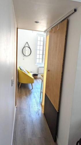 un couloir avec une porte et une chaise jaune dans la chambre dans l'établissement Studio mezzanine, à Foix