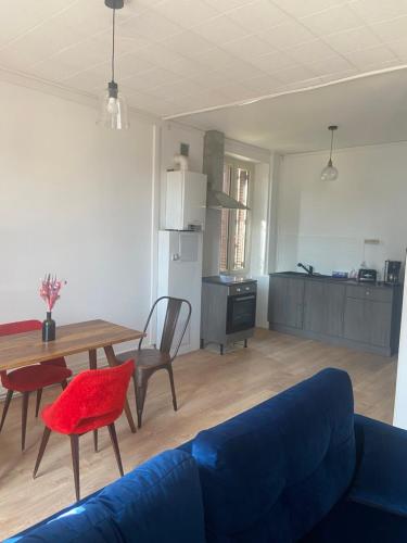 - un salon avec un canapé bleu et une table dans l'établissement Le Billeron, à Saint-Amand-Montrond