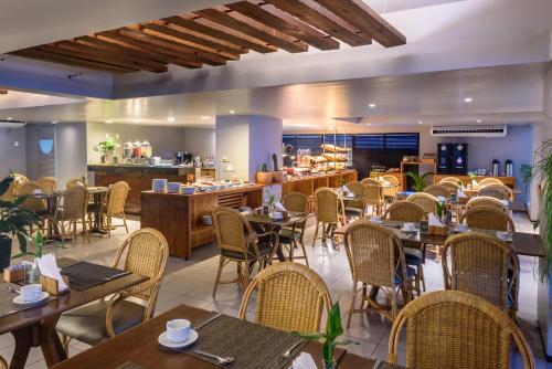a restaurant with tables and chairs and a counter at Hardman Praia Hotel in João Pessoa