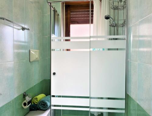 baño con ducha y puerta de cristal en Casa MARINA, en Scalea