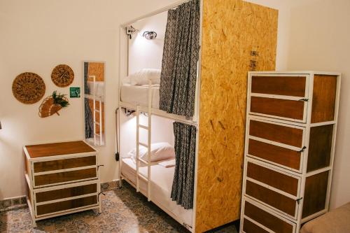 Cordova Hostel Medellin في ميديلين: غرفة بها ثلاثة أسرة بطابقين وخزانة