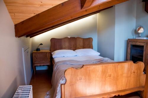 een slaapkamer met een houten bed in een kamer bij Country style attic in the heart of Preveza in Preveza