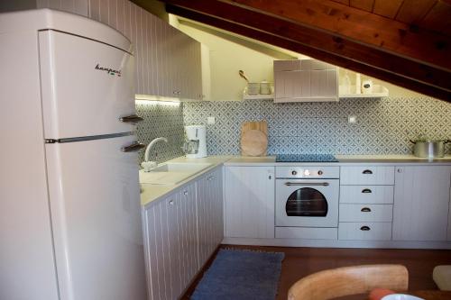 een keuken met een witte koelkast en een wastafel bij Country style attic in the heart of Preveza in Preveza