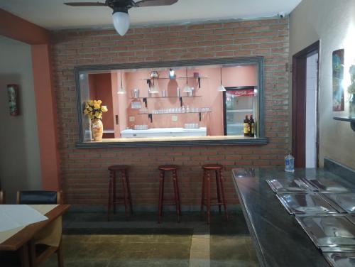 a brick wall with a window in a restaurant at Pousada Solar das Palmeiras in Joanópolis