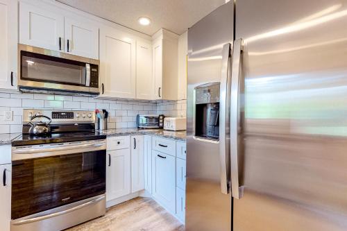 a kitchen with white cabinets and a stainless steel refrigerator at 37 Partridge Woods in Bartlett