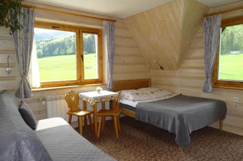 1 dormitorio con 2 camas, mesa y 2 sillas en U lisa en Zakopane