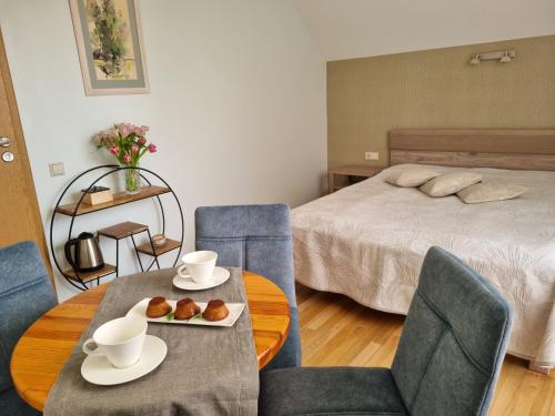 a room with a bed and a table and chairs at Birutes Apartments in Palanga