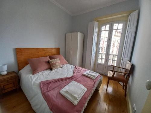 ein Schlafzimmer mit einem großen Bett mit rosa Bettwäsche in der Unterkunft CASA MARIANA 2 - Viver a Vila in Sintra