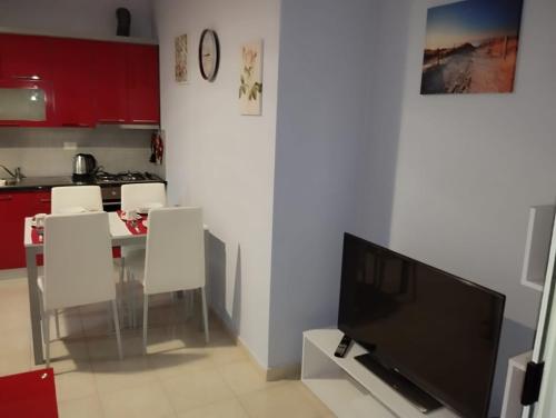 a living room with a television and a table and chairs at ARIA Apartament in Durrës