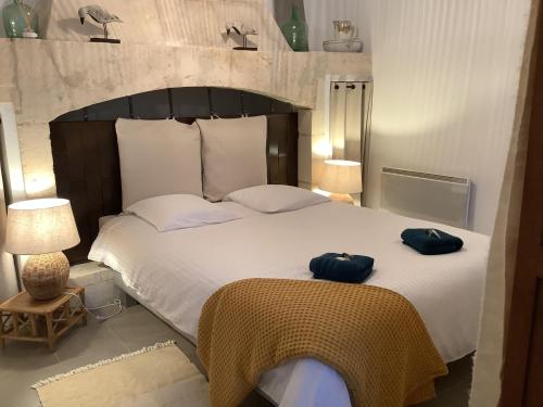 een slaapkamer met een groot bed en 2 blauwe handdoeken bij L'Oasis de La Roquette in Arles