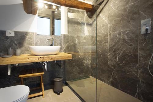 a bathroom with a sink and a glass shower at New Moon Rooms in La Spezia