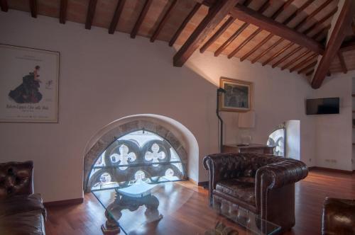 a living room with a couch and an arched window at Umbrian Concierge - Duomo Accommodations in Perugia
