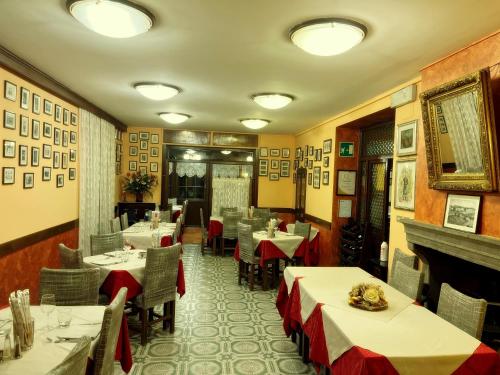 un restaurante con mesas y sillas y una chimenea en Hotel Montegrande en Vidiciatico