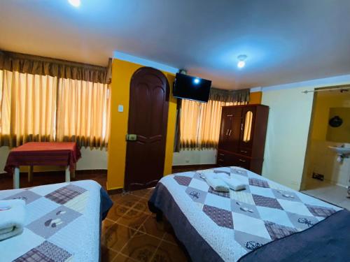 HOUSE MIRAFLORES في كاخاماركا: غرفة نوم بسريرين وتلفزيون بشاشة مسطحة